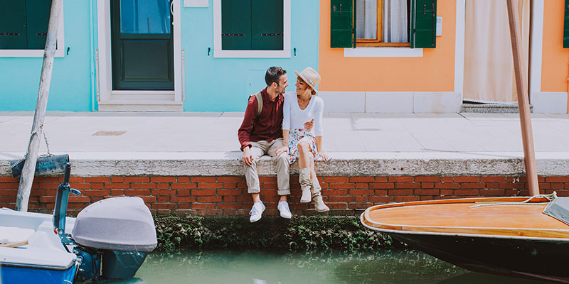 A couple sitting by the river in Venice