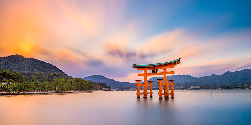 A torii gate in the water surrounded by mountains