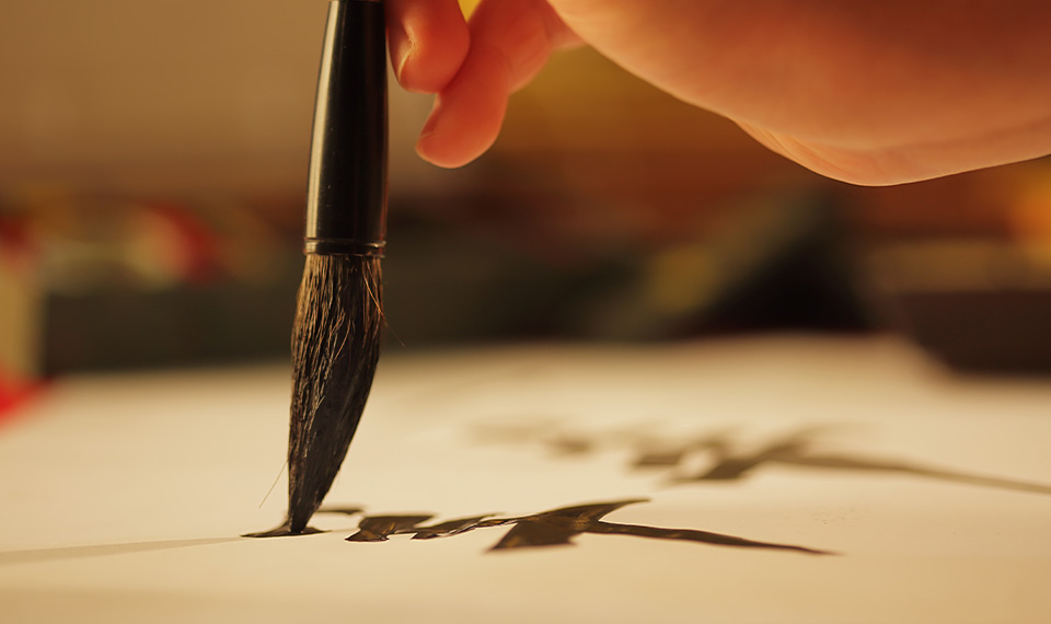 A calligraphy brush on a sheet of paper