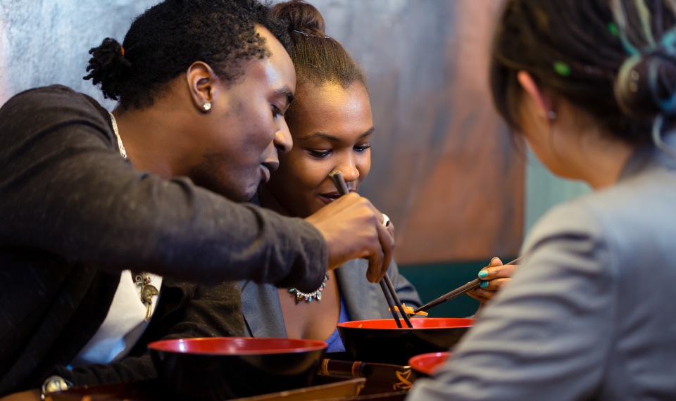 A family eating noodles at a restaurant