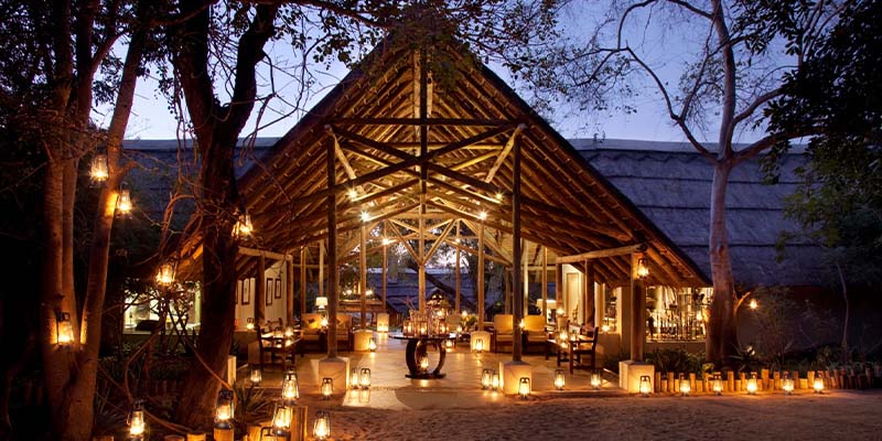 A candlelit walkway leading to an A-frame lodge