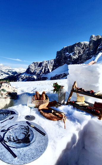Outdoor table setting with champagne in the snowy Dolomites