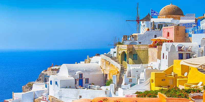 Brightly coloured buildings against an ocean backdrop