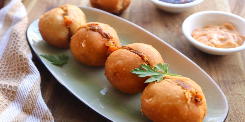 Vetkoek pieces on a serving plate