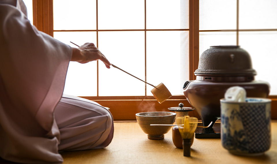 A woman in traditional dress pouring tea