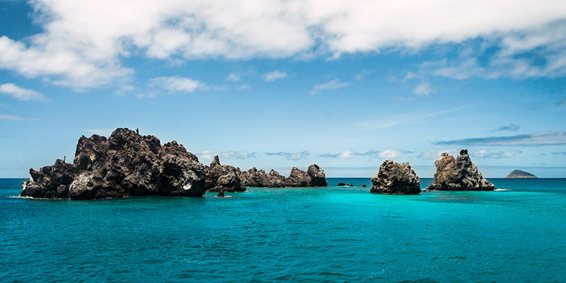 Multiple rock formations sticking out of the ocean