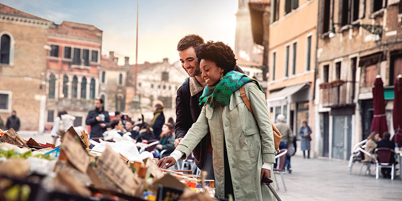 A couple looking through produce at an Italian market