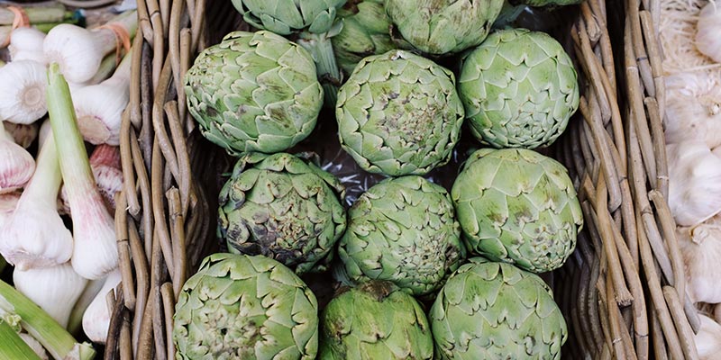 A stall front displaying artichokes and garlic