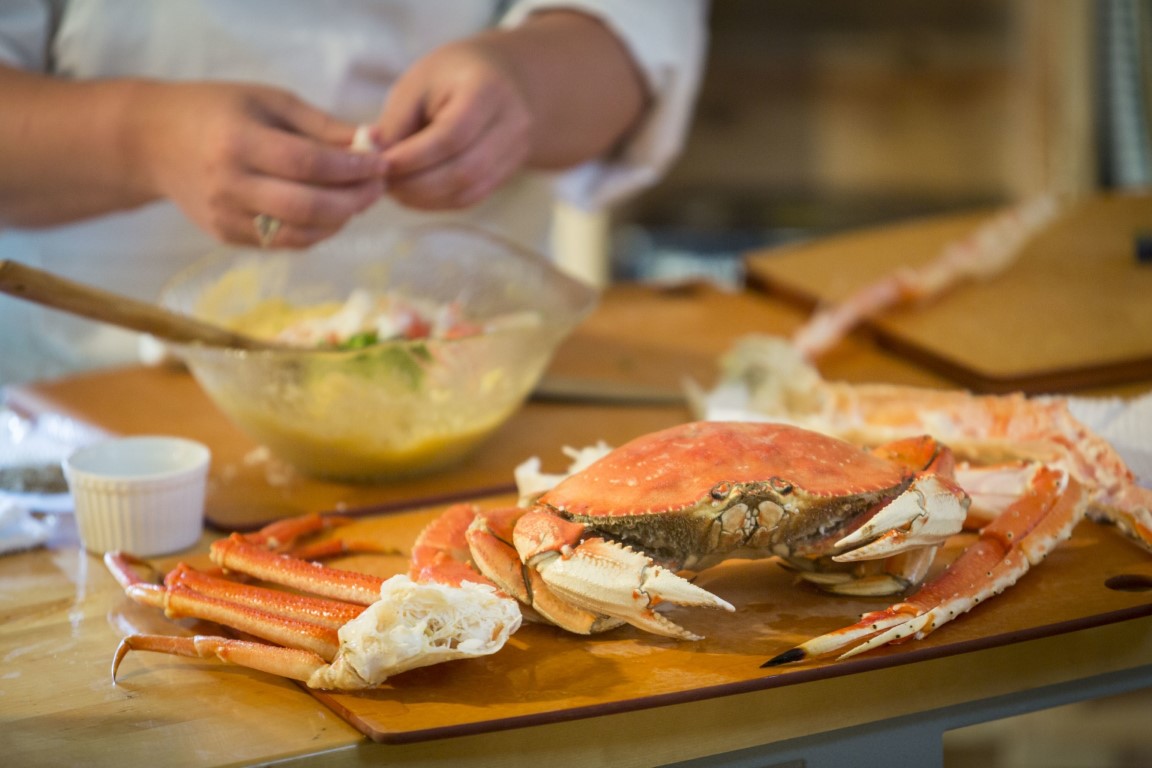 close up view of a chef preparing a crab dish