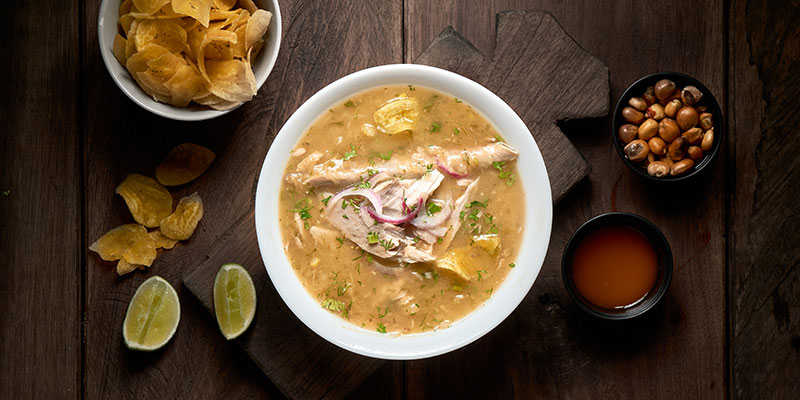 A bowl of encebollado and plantain crisps