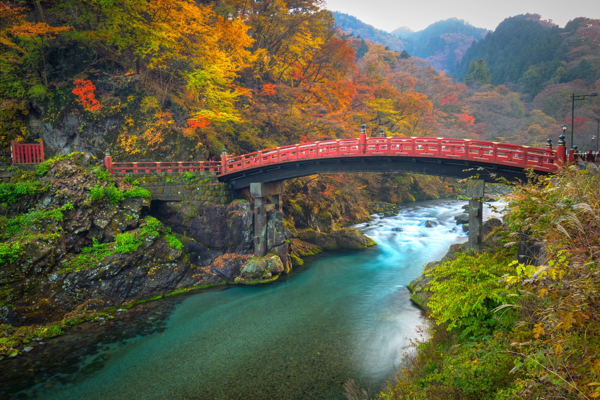A red bridge over a river in Nikko Japan during the Autumn season