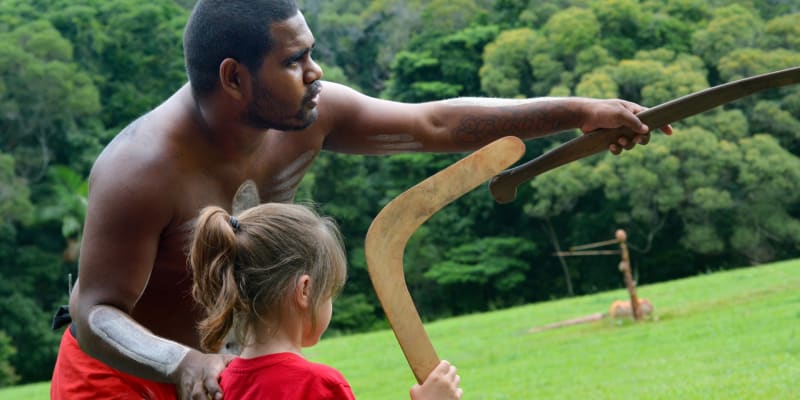 Aboriginal man with child holding a boomerang