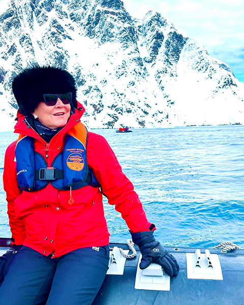 Jules sitting on the edge of a zodiac in Antarctica