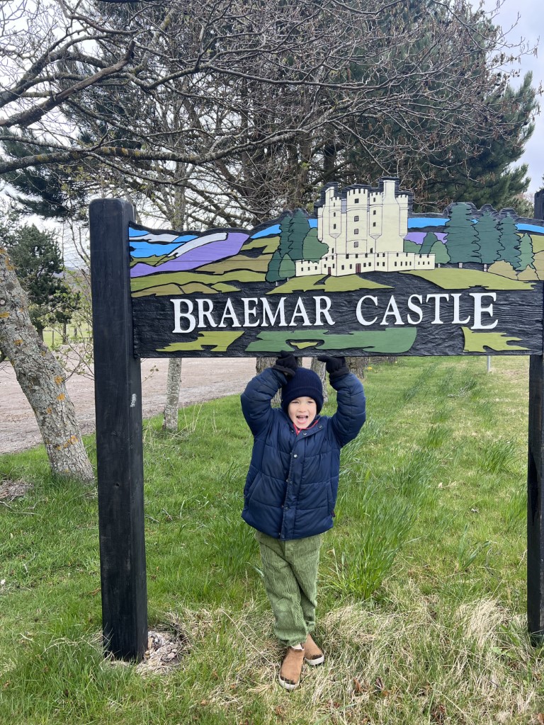 Posing in front of the Braemar Castle sign