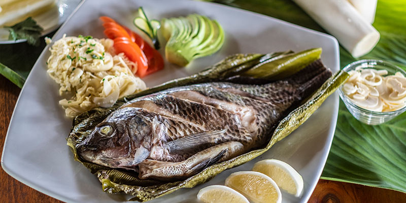 A whole fish served on a bijao leaf