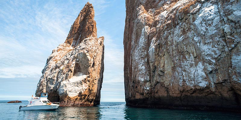 A boat sailing through kicker rock