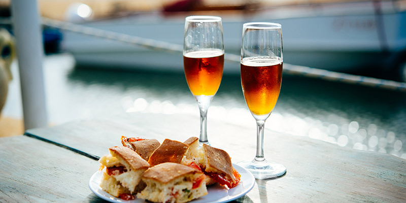 Two glasses of wine next to a plate of food