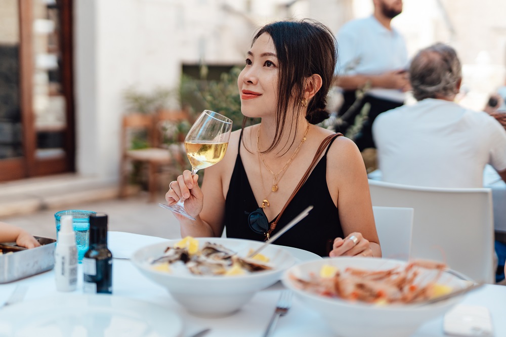 A woman enjoying French cuisine and a glass of white wine